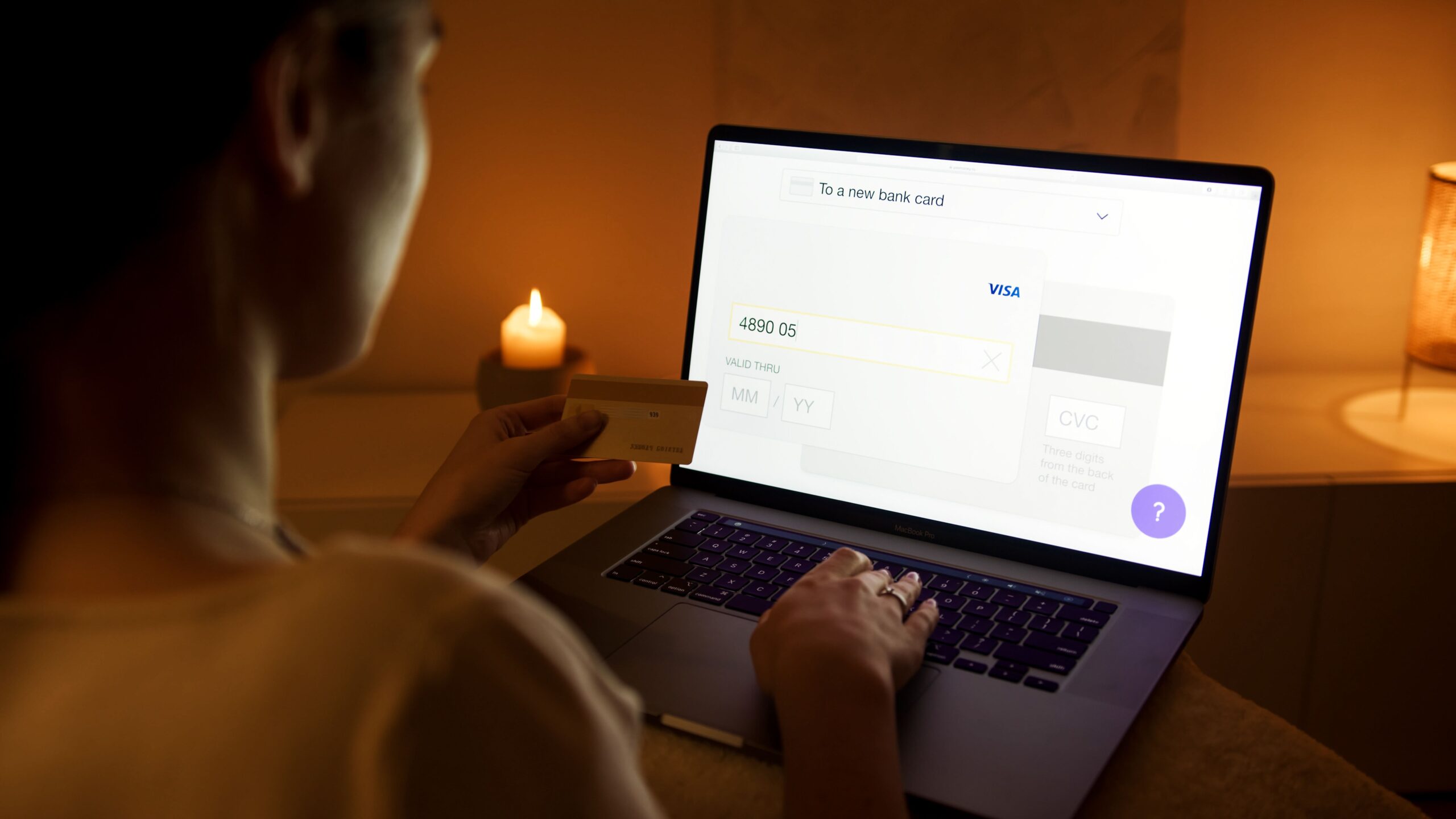 Close up of a person using a laptop and smartphone for online banking