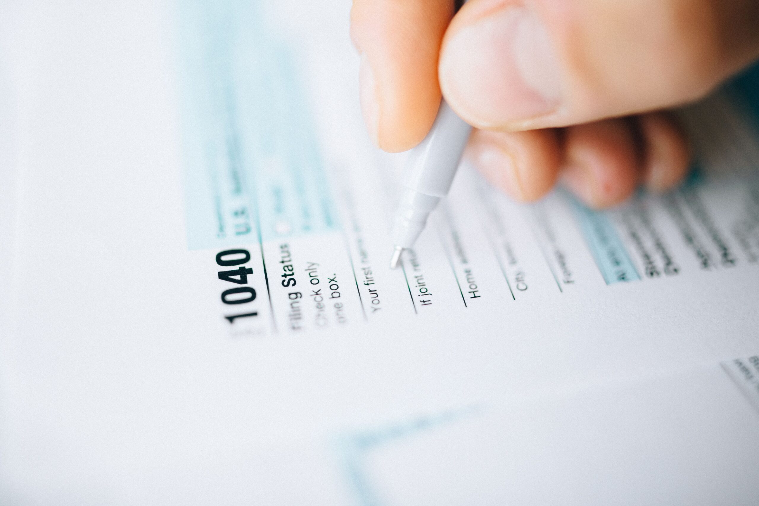 Close up of hand filling out tax forms