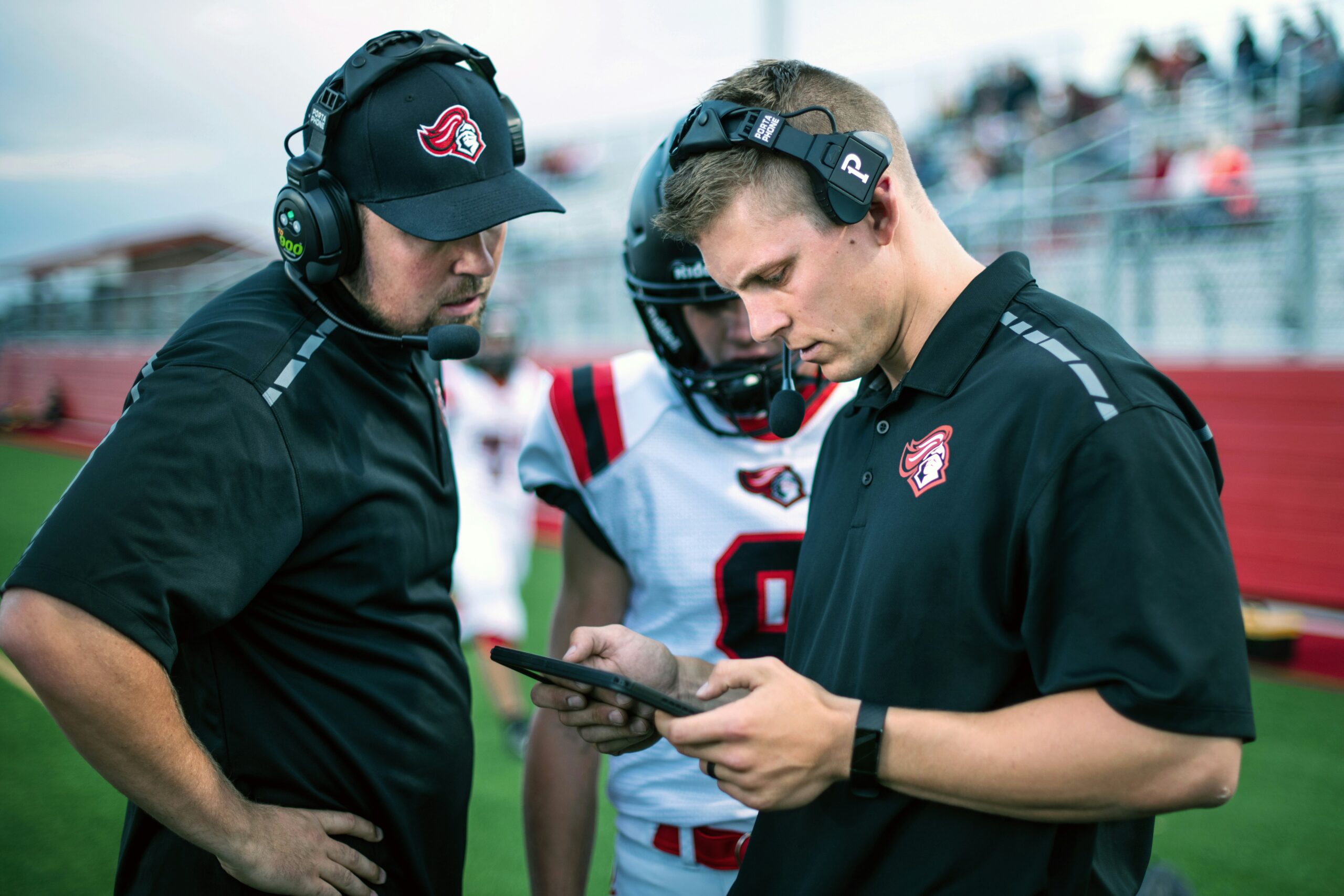 View of coach reviewing play with another coach and player